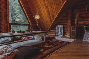 una sala de estar en una cabaña de madera con una mesa en Sabay Sai Wooden Guesthouse in The National Park en Almaty