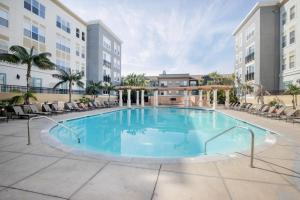a large pool in a courtyard with chairs and buildings at Santana Row 2br w gym pool nr highways SFO-1156 in San Jose