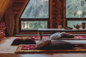Habitación con 2 almohadas en el suelo y mesa en Sabay Sai Wooden Guesthouse in The National Park, en Almaty