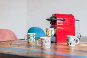 einen Tisch mit vier Kaffeetassen und einem Toaster in der Unterkunft FLAIR: Ruheoase vor der Stadt in Mannheim