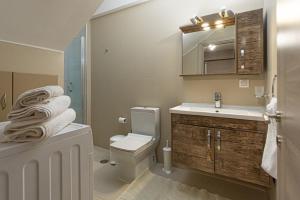 a bathroom with a toilet and a sink and a mirror at Cosy apartment near Karfas Beach in Chios