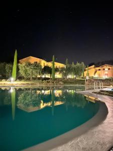 モンテプルチャーノにあるCasa Vacanze Il Faggioの夜間の建物前の水のプール
