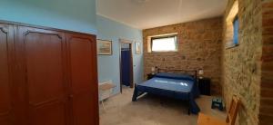 1 dormitorio con cama y pared de ladrillo en Agriturismo Il Sassolino, en Ripalvella