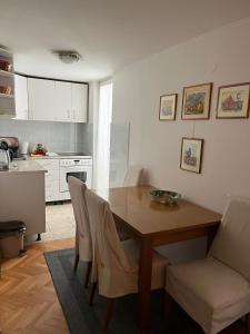 a kitchen with a wooden table and chairs in a kitchen at Apartment Centropolis in Mostar