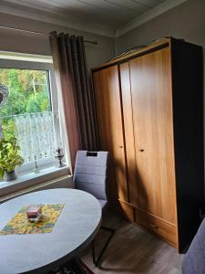 um quarto com uma mesa, um armário e uma janela em Ferienwohnung 2 Am Park em Divitz