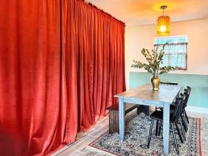 a dining room with a red curtain and a table at Hummingbird Hideaway, Tropical 3-Bed Guest House in South Tampa in Tampa