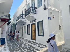 a group of people walking down a street next to buildings at Myconian Old Town Maisonette THE MIMIs PLACE in Mikonos