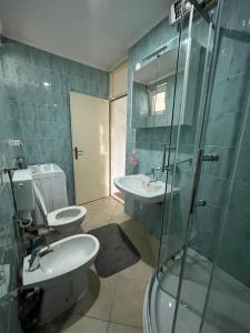 a bathroom with a toilet and a sink and a shower at Apartment Centropolis in Mostar +8 photos