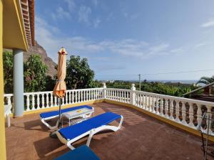 a balcony with two chairs and an umbrella at Casa Gloria in Valle Gran Rey