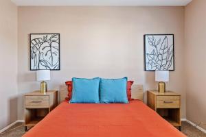 ein Schlafzimmer mit einem Bett mit orangefarbener Bettwäsche und zwei Lampen in der Unterkunft Southwestern Style Home Near Old Town Scottsdale in Scottsdale