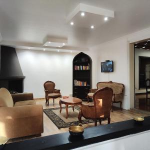 a living room with couches and chairs and a tv at Hotel Muros Quito in Quito