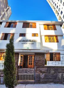 un edificio blanco con un árbol delante en Hotel Muros Quito en Quito