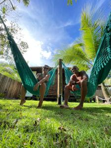um par de pessoas sentadas em redes na relva em Cabana Fluir - Taipu de Fora - Península de Maraú em Barra Grande
