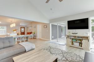 a living room with a couch and a kitchen at Dock and Sunset Views Lakeside Ozark Retreat! in Lake Ozark