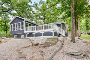 a large house with a balcony on top of a yard at Dock and Sunset Views Lakeside Ozark Retreat! in Lake Ozark