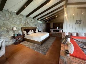 a bedroom with a bed and a stone wall at Secret Harbour Boutique Hotel and Marina in Lance aux Épines