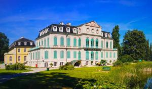 a large white building with green windows at Apartment mit Blick auf Herkules mit Parkplatz in Kassel