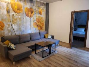 uma sala de estar com um sofá e uma mesa em Aparthotel Krzywa em Katowice