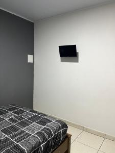 ein Schlafzimmer mit einem Bett und einem TV an der Wand in der Unterkunft Casa de temporada Stracini in Taquaritinga