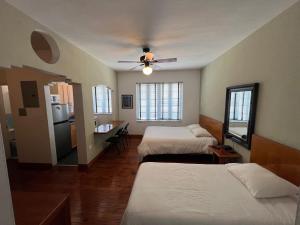 Sherbrooke All Suites Hotel في ميامي بيتش: غرفة نوم بسريرين ومروحة سقف