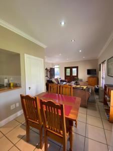 eine Küche und ein Wohnzimmer mit einem Holztisch und Stühlen in der Unterkunft @Leisure Guest Suite in Stellenbosch