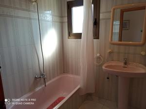 een badkamer met een bad en een wastafel bij Villa Chalet Riomar Playa Oliva in Oliva