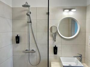 a bathroom with a shower with a sink and a mirror at Christina Residence in Budapest