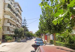 ulica z samochodami zaparkowanymi obok budynku w obiekcie Kremou Studio w Atenach