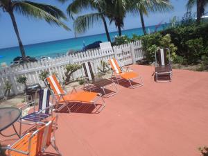 a group of chairs sitting on a patio near the beach at Annabelle's in Saint James