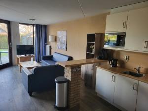 a kitchen and living room with a couch and a table at Het Pareltje in Brouwershaven