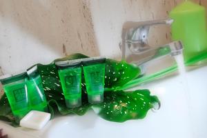 un grupo de tazas verdes de plástico sentadas en un fregadero en Hotel Scott House, en Roma