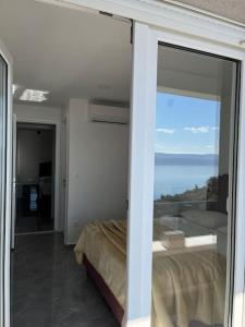 Schlafzimmer mit Meerblick durch eine Glasschiebetür in der Unterkunft Villa Lelas-Apartment Mediterraneo in Omiš