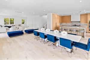 une cuisine avec une table blanche et des chaises bleues dans l'établissement Charming 7-Bedroom Southampton Compound, à Southampton