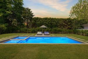 a swimming pool in the middle of a yard at Charming 7-Bedroom Southampton Compound in Southampton