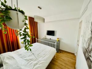 ein Schlafzimmer mit einem Bett und einer Topfpflanze in der Unterkunft Union Experience - City Center in Timişoara
