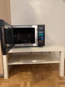 a microwave oven sitting on a white shelf at Apartment Blick auf Schloss Herkules Kassel in Kassel