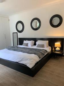 1 dormitorio con 1 cama grande y 2 espejos en la pared en Regent Casa’s, en Ciudad del Cabo