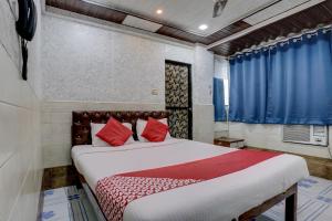 a bedroom with a large bed with red pillows at OYO Flagship Hotel Sapna Residency in Mumbai