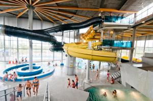 una grande piscina coperta con persone in acqua di Spa Tervise Paradiis a Pärnu