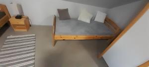 um quarto com uma cama de madeira com almofadas em Studio-Apartment Braunschweig in Wolfenbüttel em Volfembutel