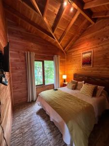 a bedroom with a large bed in a log cabin at Santa Dominga in Licán Ray