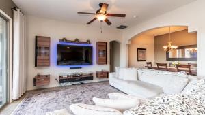 Il comprend un salon doté d'un canapé blanc et d'une télévision à écran plat. dans l'établissement The Oasis -Heated pool and games, à Liberty