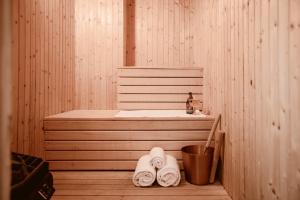 a sauna with two towels and a tub and a bucket at Vadstena Klosterhotell Konferens & Spa in Vadstena