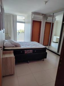 un lit dans une chambre avec un grand miroir dans l'établissement Sobrado Ótima Localização, à Goiânia