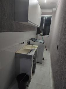 une petite cuisine avec un évier et une cuisinière dans l'établissement Sobrado Ótima Localização, à Goiânia