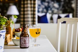 eine Flasche Bier auf einem Tisch neben einem Glas in der Unterkunft Vadstena Klosterhotell Konferens & Spa in Vadstena