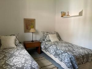 sypialnia z 2 łóżkami i stołem z lampką w obiekcie La Casita w mieście La Cumbre