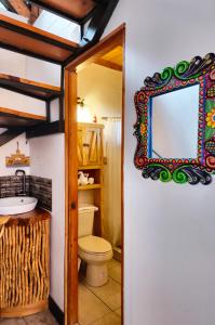 a bathroom with a toilet and a mirror at Hotel Casa Realeza in Antigua Guatemala