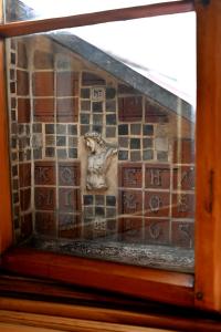 een glazen raam met een bakstenen muur met een standbeeld bij Colibri Foto Design in Kłodzko