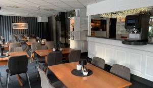 restauracja ze stołami i krzesłami oraz bar w obiekcie Bodø Hotel w mieście Bodø